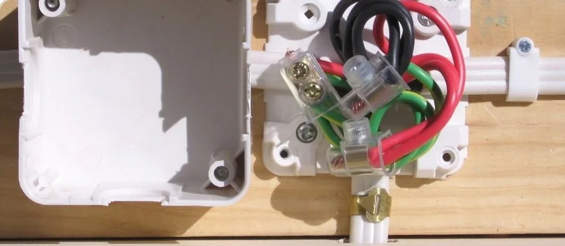 Quadro elétrico aberto com bornes e fios coloridos conectados